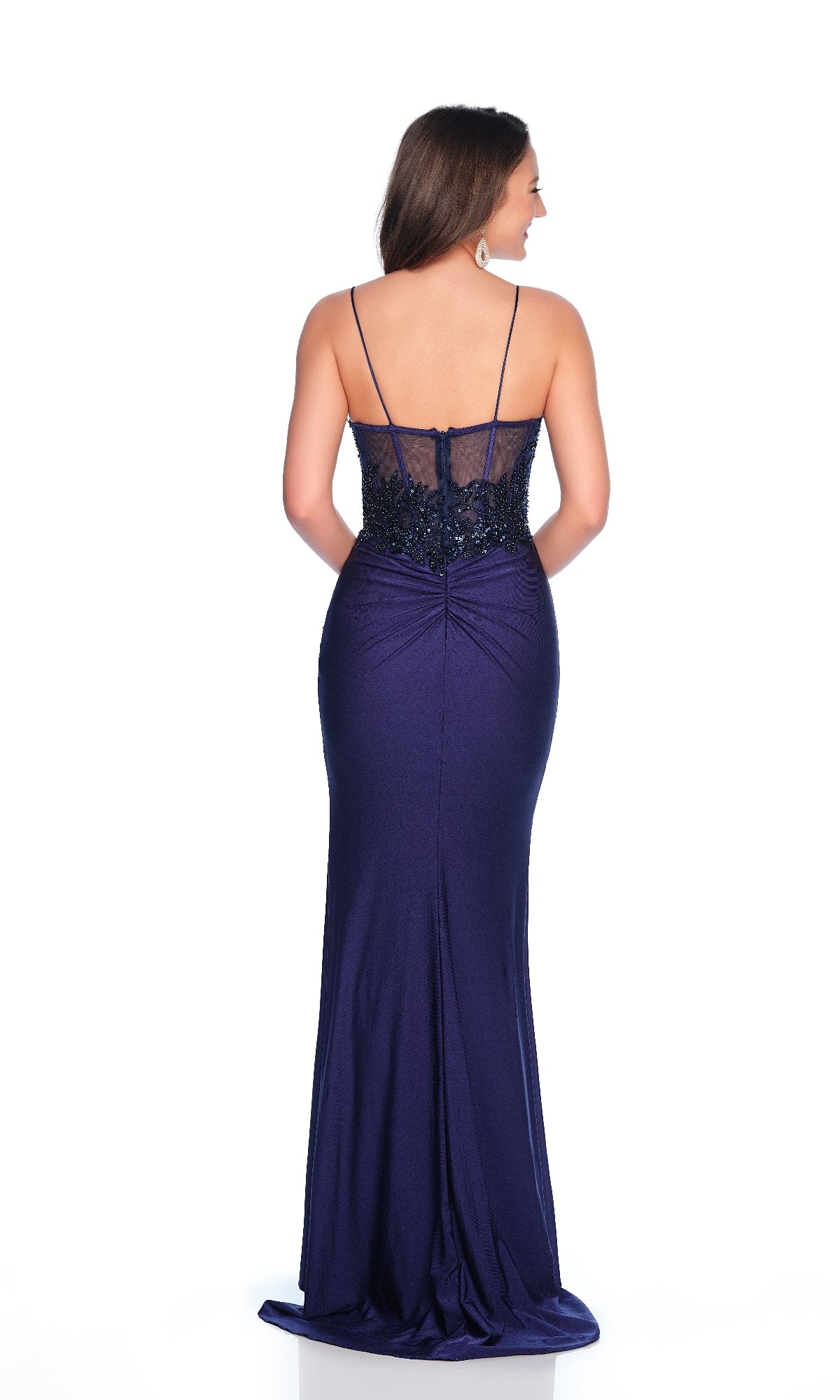 A woman faces away, wearing the Dave & Johnny 12255 long navy blue prom dress featuring a wide leg slit and a sheer, embellished back panel.